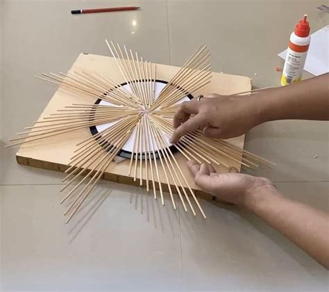 Someone Is Making A Sunburst Out Of Popsicle Sticks On The Table Top