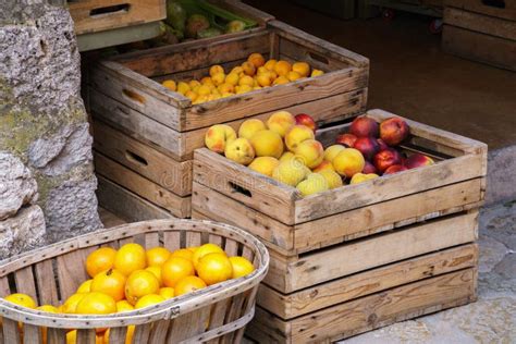 Naranjas Y Melocotones Maduros En Caja De Madera Y Cesta En Un Mercado