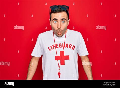 Handsome Lifeguard Man Wearing T Shirt With Red Cross And Whistle Over