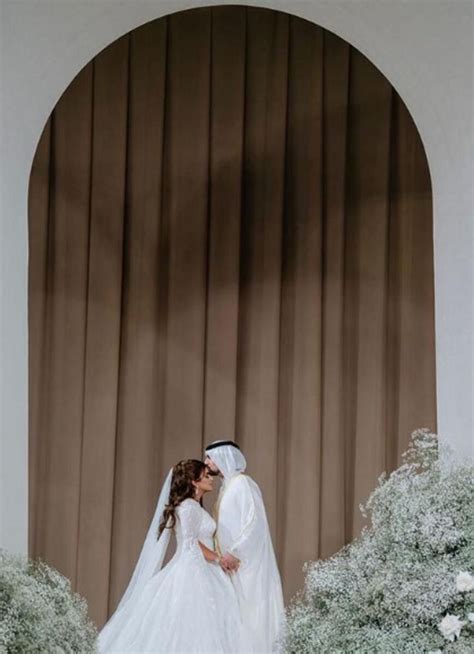 A Bride And Groom Kissing In Front Of A Window