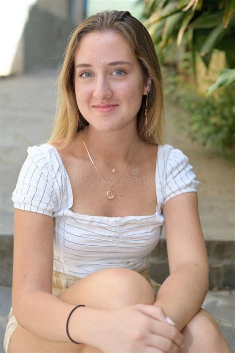 Blonde Girl With Blue Eyes Smiles Looking At The Camera Stock Photo