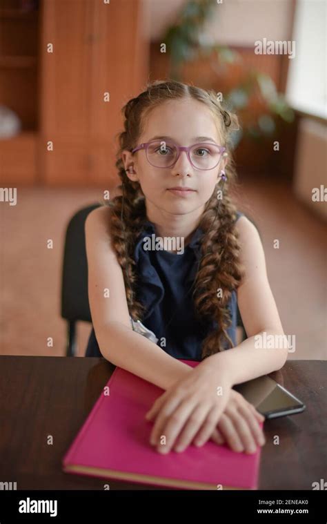 Écolière Assise à La Table Avec Des Manuels Scolaires Dans La Salle De