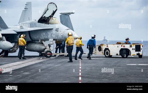 Sailors Move An F A C Hornet Across The Flight Deck Aboard The