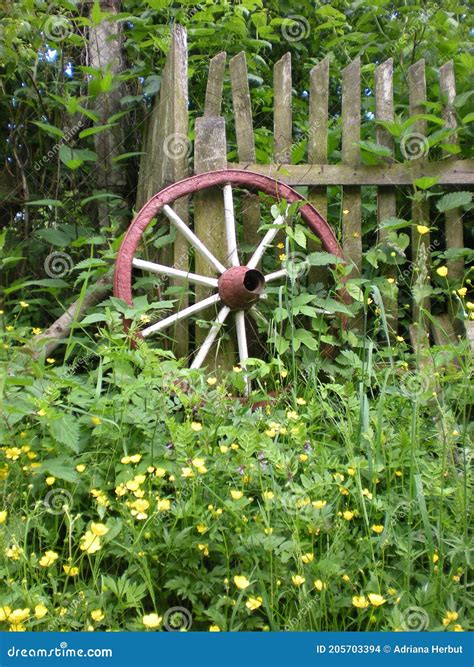 Old Painted Cartwheel Leaning On A Wooden Fence Stock Photo Image Of