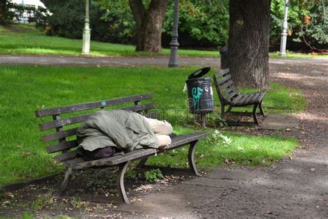 Homeless Man Sleeping On Park Bench