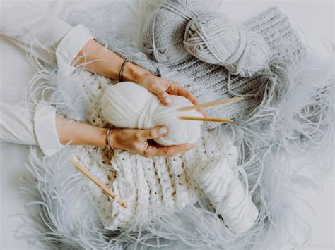 Premium Photo Cropped Hands Of Woman Holding Wool On Bed