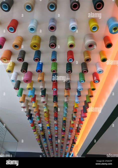 A Display In Lines Of Spools Of Coloured Threads On The Ceiling At