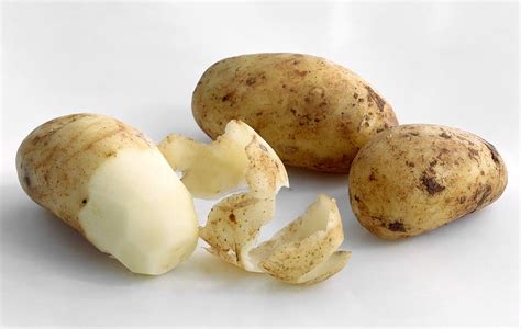 Unpeeled And Peeled Potatoes By Science Photo Library