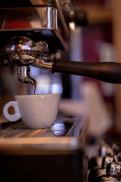 Cafetera haciendo café en una taza blanca Foto Premium