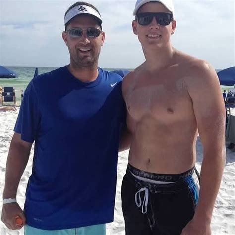 Two Men Standing Next To Each Other On A Beach