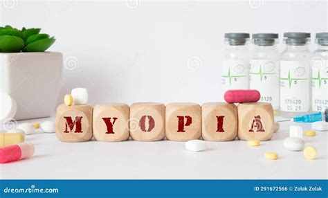 On A Blue Background Stethoscope And Wooden Block With The Word Myopia