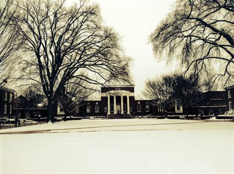 An Old Photo Of A Building And Trees In The Snow With No Leaves On It