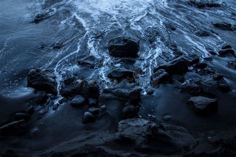 Waves Moving To The Dark Blue Seashore Covered With Rocks Stock Image