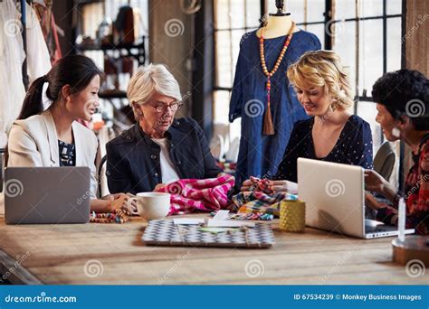 Four Fashion Designers In Meeting Discussing Textiles Stock Image