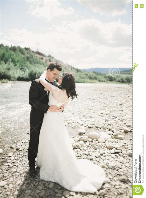 Beautifull Wedding Couple Kissing And Embracing Near The Shore Of A