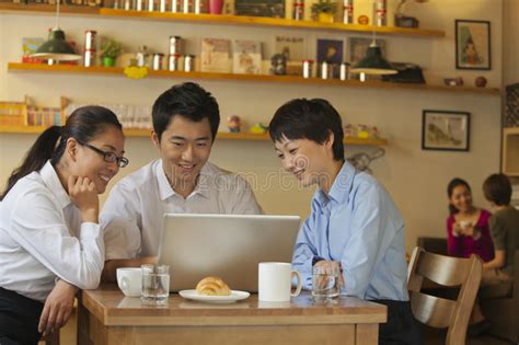 Tres Amigos Que Se Sientan En La Cafeter A Mirando Abajo El Ordenador