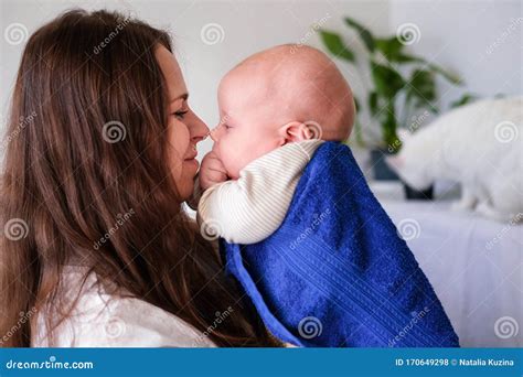 Mom Hugs Her Little Cutest Baby After Bath With Blue Towel On Head