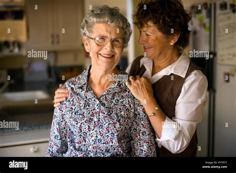 Smiling Mature Woman Gives Her Elderly Mother An Affectionate Squeeze Stock Photo Alamy