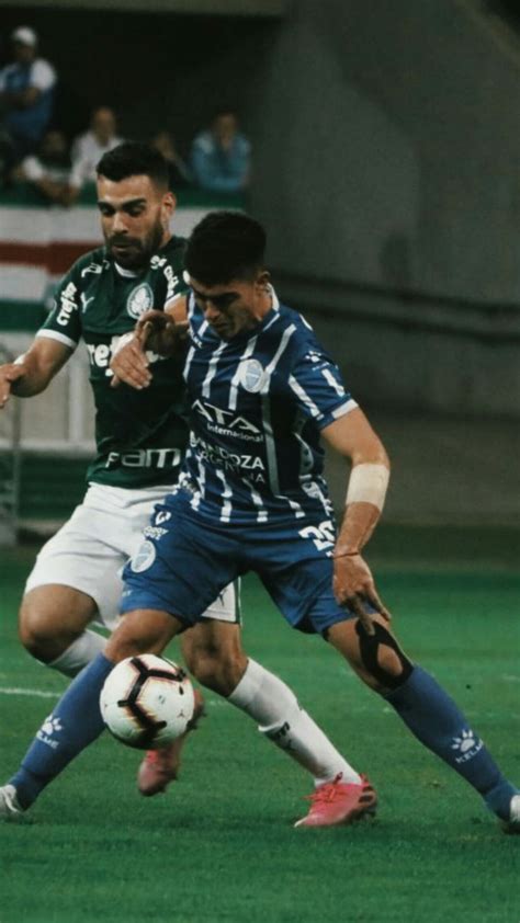 Two Soccer Players Are Fighting For The Ball In Front Of Each Other On