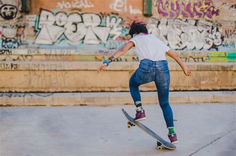 Brunette Girl Riding Skateboard Making Tricks Photo Gratuite