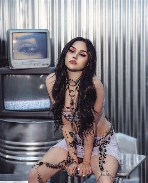 A Woman Sitting On Top Of A Chair In Front Of A Tv Set And Wearing Chains