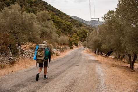 Vista Trasera Del Hombre Turista Con Mochila Y Palos De Senderismo