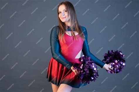 Premium Photo Happy Cheerleader Girl In Uniform Dancing With Pompoms Isolated On Grey Background