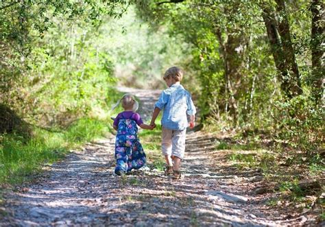 Children walking hand-in-hand outdoors - Stock Photo - Dissolve