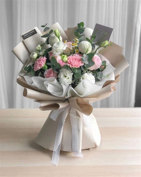 A Bouquet Of White And Pink Flowers On A Table