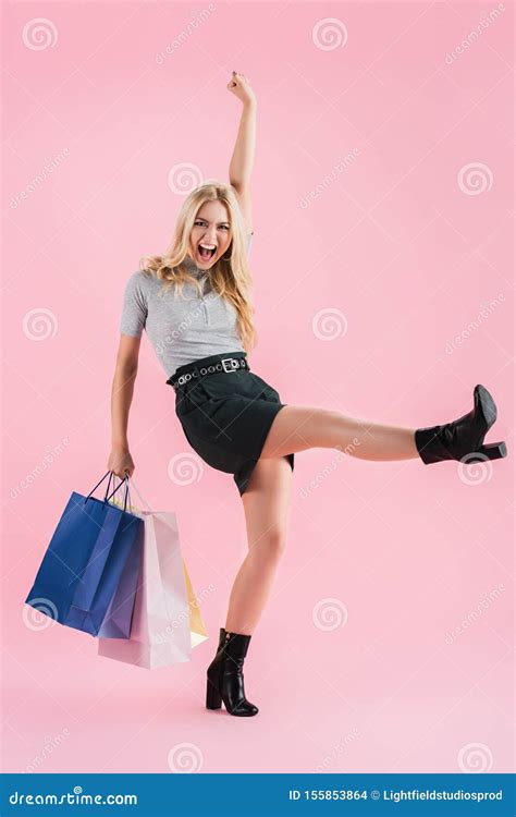 Cheerful Blonde Girl Dancing With Shopping Bags Isolated Stock Photo