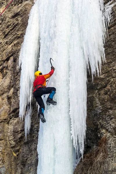 Extreme Ice Climbing Man Climbing The Frozen Waterfall Using Ice Axes