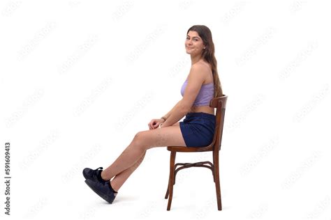 Side View Of A Young Girl Sitting On Chair With Stretched Legs And