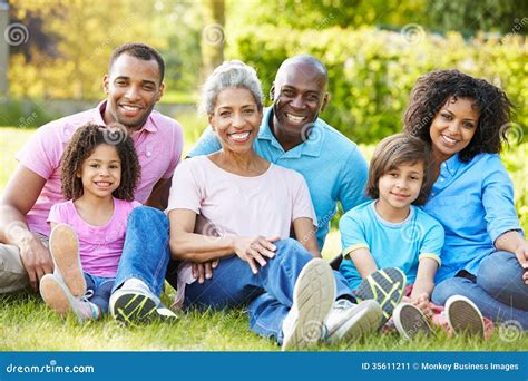 Familia Afroamericana De La Generación Multi Que Se Sienta En Jardín