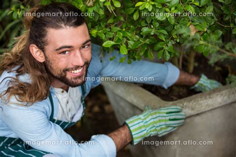 Portrait Of Happy Worker Planting At Community Garden