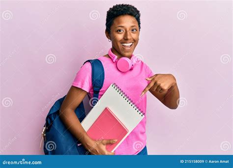 Young African American Girl Wearing School Bag And Holding Books