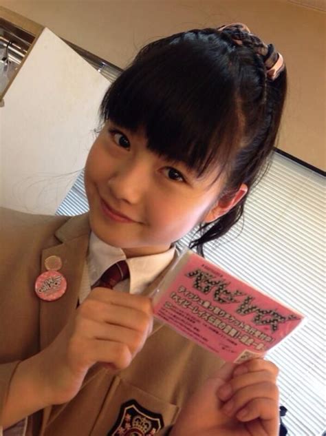 A Girl In Uniform Holding Up A Pink Card