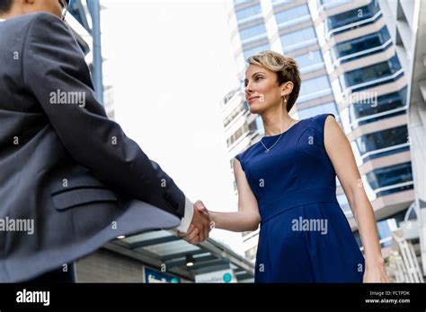 Businesswoman Standing And Talking To Her Colleague Outdoors Stock