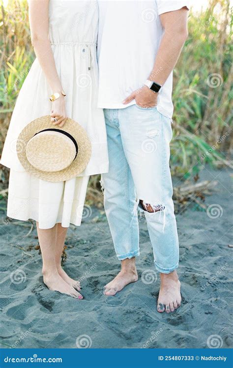 Man And Woman Stand Next To Each Other Barefoot On The Sand Stock Image