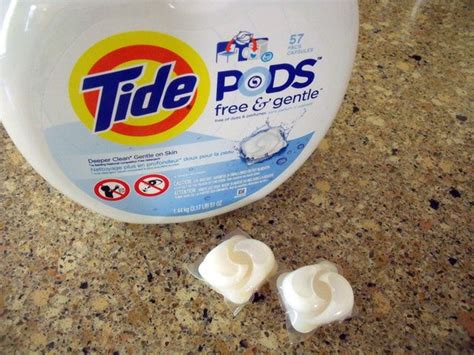 Tide Pods Sitting On Top Of A Counter Next To Two Pieces Of White Toilet Paper