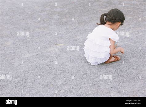 Enfant Accroupi Dans Le Sable Banque De Photographies Et Dimages à