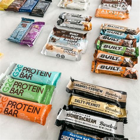 An Assortment Of Protein Bars Laid Out On Top Of A Table Next To Each Other