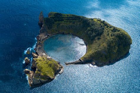 Aerial View Of Stunning Small Triangular Island With Trees And Cliffs