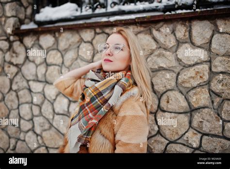 Portraiy Of Blonde Girl In Glasses Red Fur Coat And Scarf At Winter
