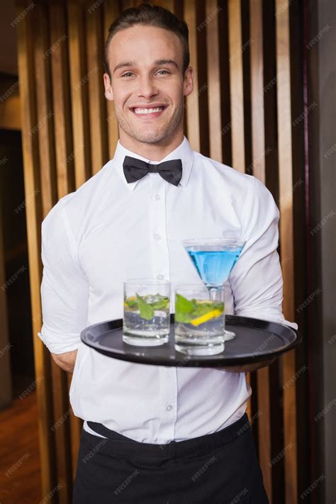 Premium Photo Cheerful Young Waiter Holding Tray With Cocktails