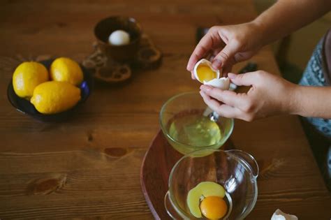 Premium Photo Womans Hands Cracking A Whole Egg Into A Bowl