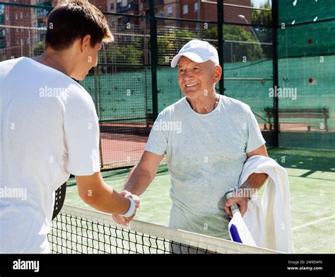 Padel players of different generations shake hands before padel match Stock Photo - Alamy