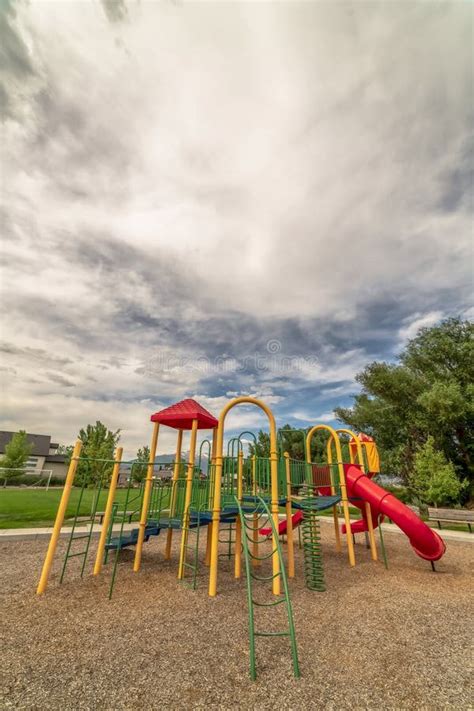 Focus On The Colorful Playground At A Park With Blue Sky And Clouds