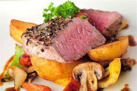 Saftiges Steak Mit Ofenkartoffeln Und Paprikas Stockfoto Bild Von