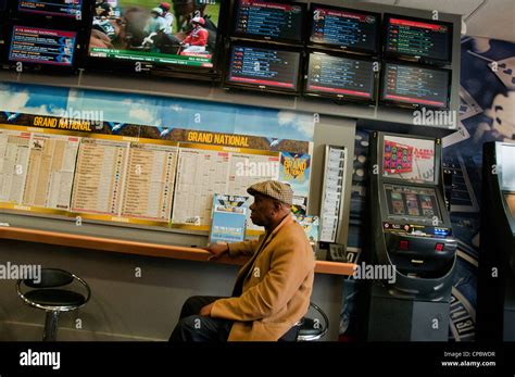 People In Betting Shop Placing Bets During Grand National Horse Race