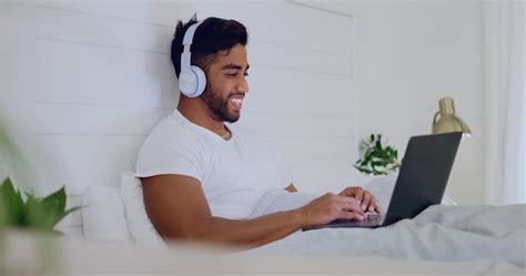 Premium Photo | Movie laughing and man in bed with a laptop for ...